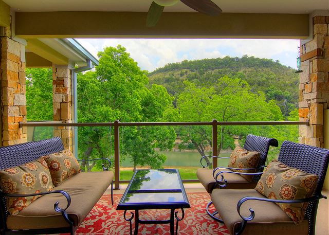 Vacation home covered balcony with ceiling fan and furniture.