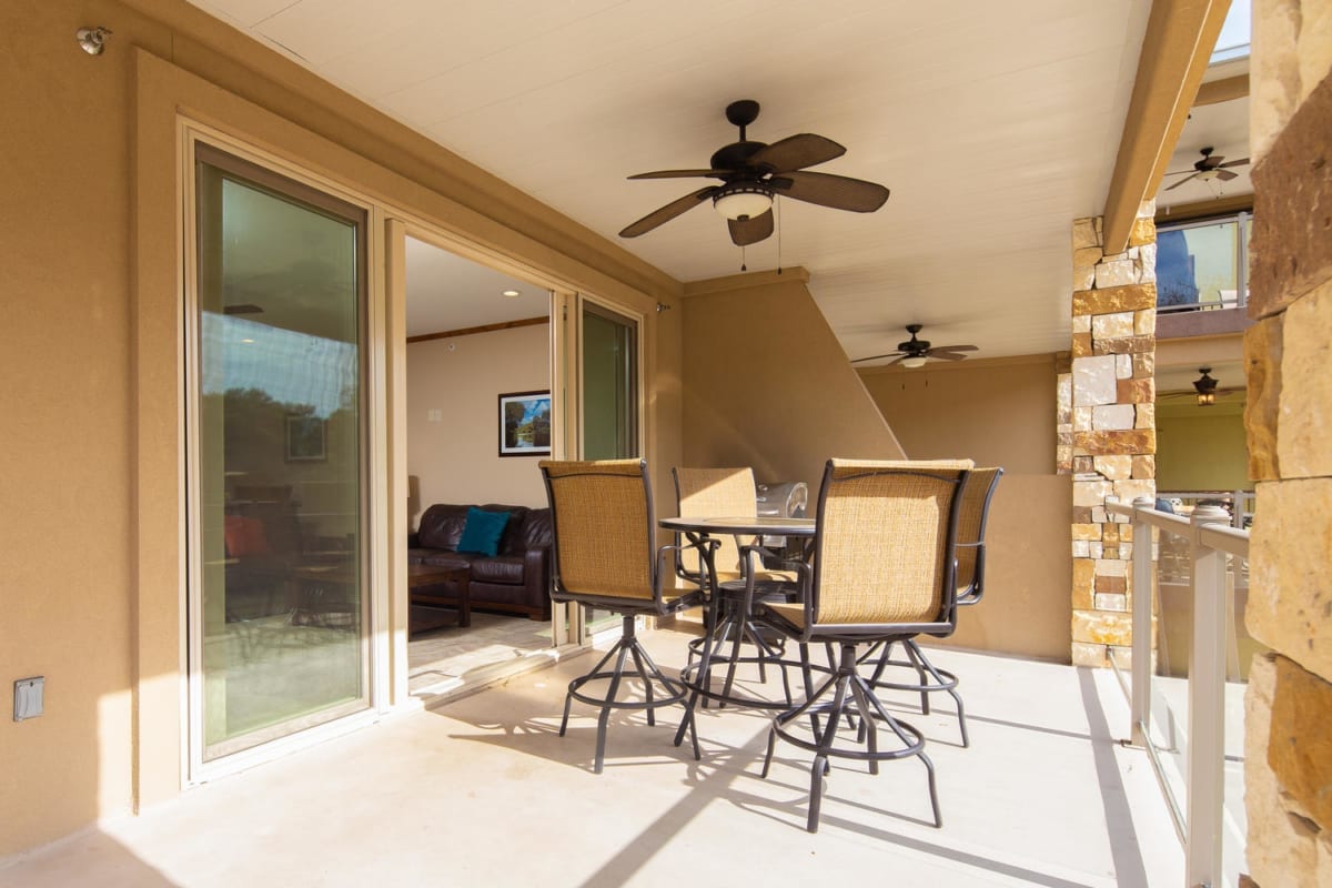 River Run Unit 209 covered balcony with ceiling fan and furniture.