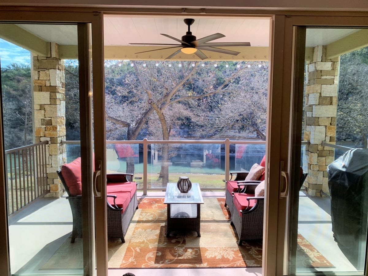 Rio Guadalupe covered balcony with ceiling fan and furniture.