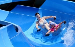 Woman and child tubing down a waterslide.