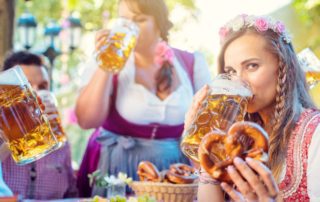A woman with friends drinking a beer at Wurstfest in New Braunfels.