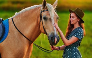 A woman petting a horse after riding in Texas.